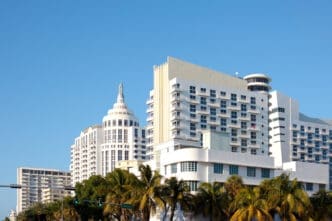 The Art Deco style buildings of Miami Beach stand against a clear blue sky.