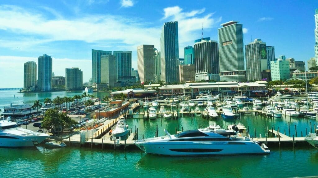 A vibrant image of a marina filled with boats, with the Miami skyline in the background
