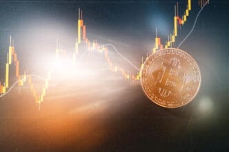 A golden Bitcoin coin is positioned on a digital screen displaying a financial candlestick chart that shows a clear upward trend, with a bright light flare coming from the left.