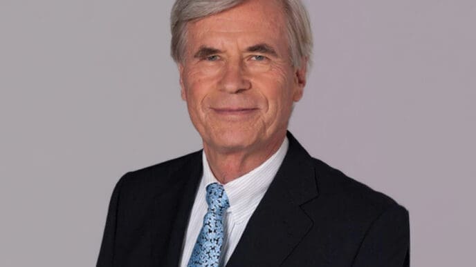 A professional portrait of German billionaire Dieter Schwarz, smiling and wearing a suit and tie.
