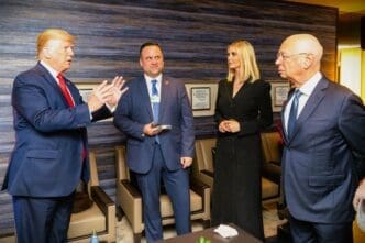 Donald Trump gestures while speaking to Klaus Schwab as Ivanka Trump and Dan Scavino look on