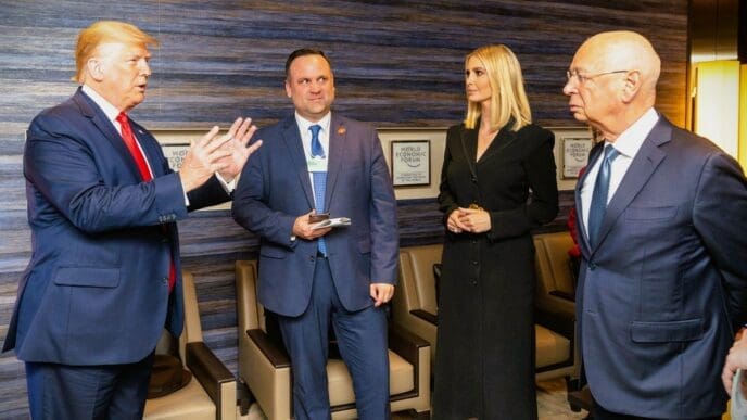 Donald Trump gestures while speaking to Klaus Schwab as Ivanka Trump and Dan Scavino look on