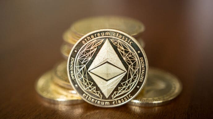 A close-up, low-angle shot of a gold Ethereum Classic cryptocurrency coin