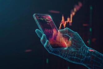 A digital wireframe hand holds a smartphone that displays a glowing financial chart, with a larger red and yellow chart in the dark background.