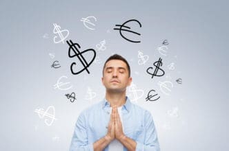 A man with his eyes closed and hands clasped in front of him, surrounded by floating dollar and euro signs.