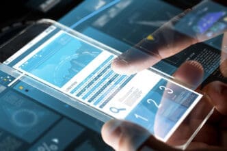 A person's finger is touching a transparent smartphone screen displaying a business chart.