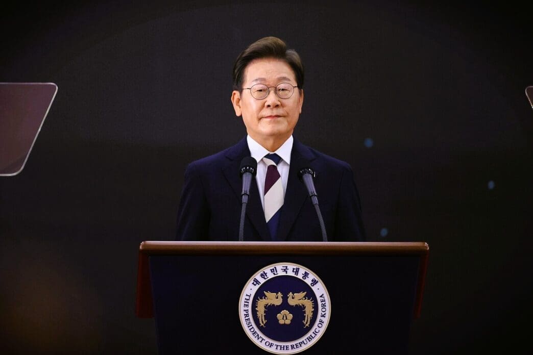 Lee Jae-myung speaks from a podium with the official presidential seal in front of him