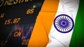 A composite image with a fabric-textured Indian flag on the right and a blurry digital screen displaying financial data and charts on the left.