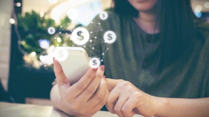A person is holding a smartphone that has a digitally overlaid graphic of a network of glowing dollar signs connected by lines.