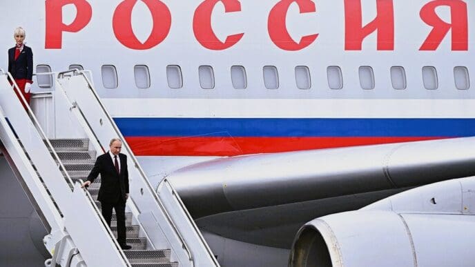 Russian President Vladimir Putin disembarks from his airplane, walking down the stairs in Anchorage, Alaska.