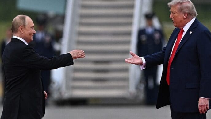 U.S. President Trump and Russian President Putin greet each other with extended hands on an airport tarmac in Anchorage, Alaska.