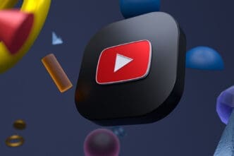A three-dimensional rendering of the YouTube logo with a black background and floating geometric shapes