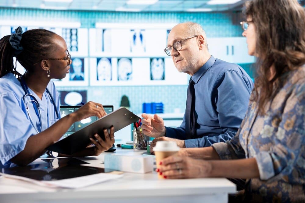 An African American medical assistant reviews patient records during a checkup.