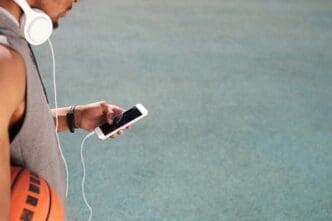 An African man uses a smartphone, likely outdoors.