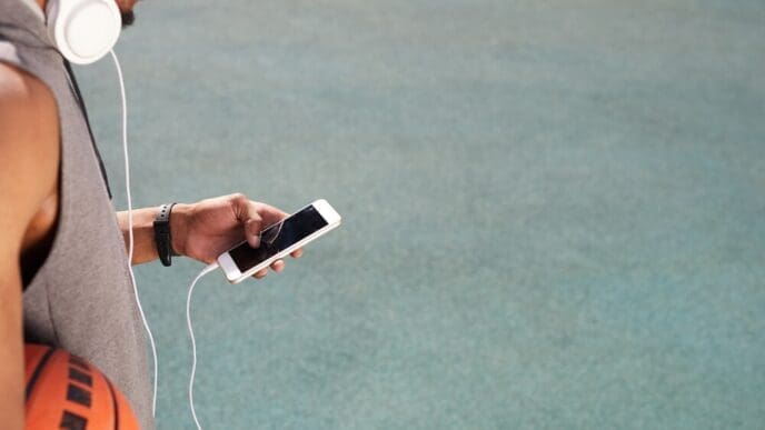 An African man uses a smartphone, likely outdoors.