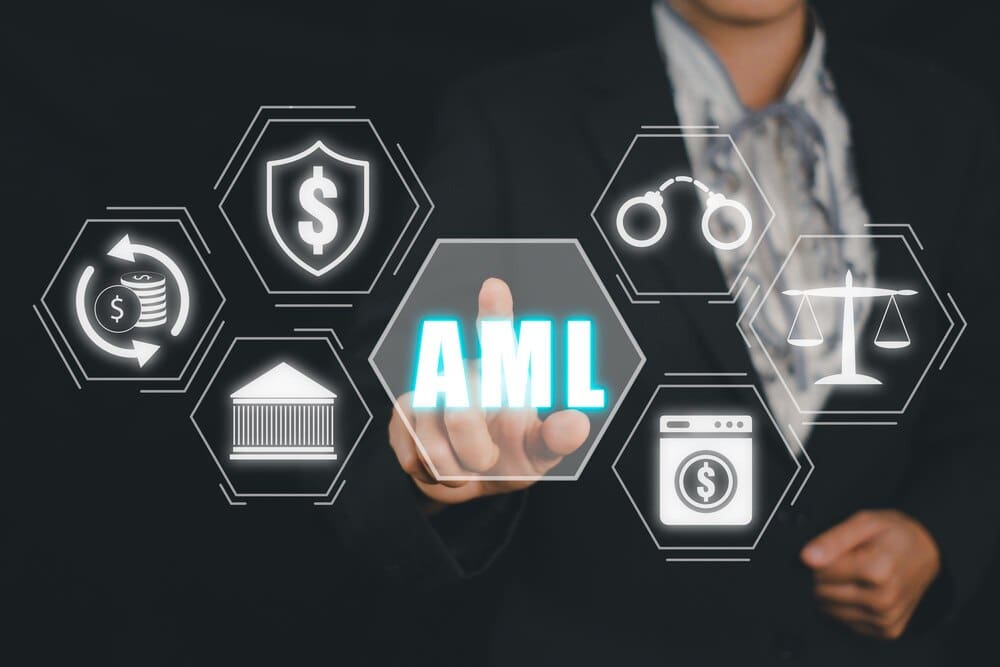 Person's hand presses a virtual button displaying an AML (Anti-Money Laundering) icon on a screen.