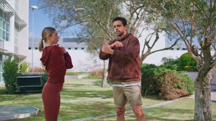 A couple of athletes stretch their hands while training together with a personal coach.