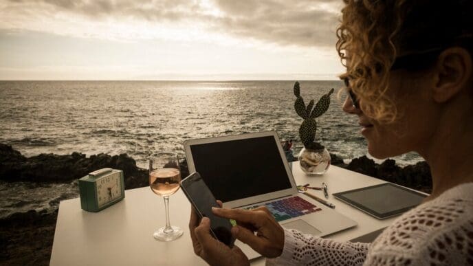 A professional woman works in a modern office with an ocean view.
