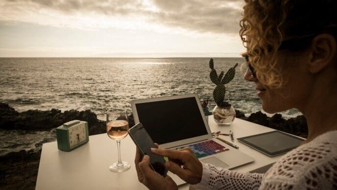 A professional woman works in a modern office with an ocean view.