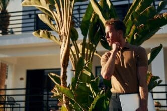 Young man standing outdoors in sunlight, enjoying a vacation in nature.