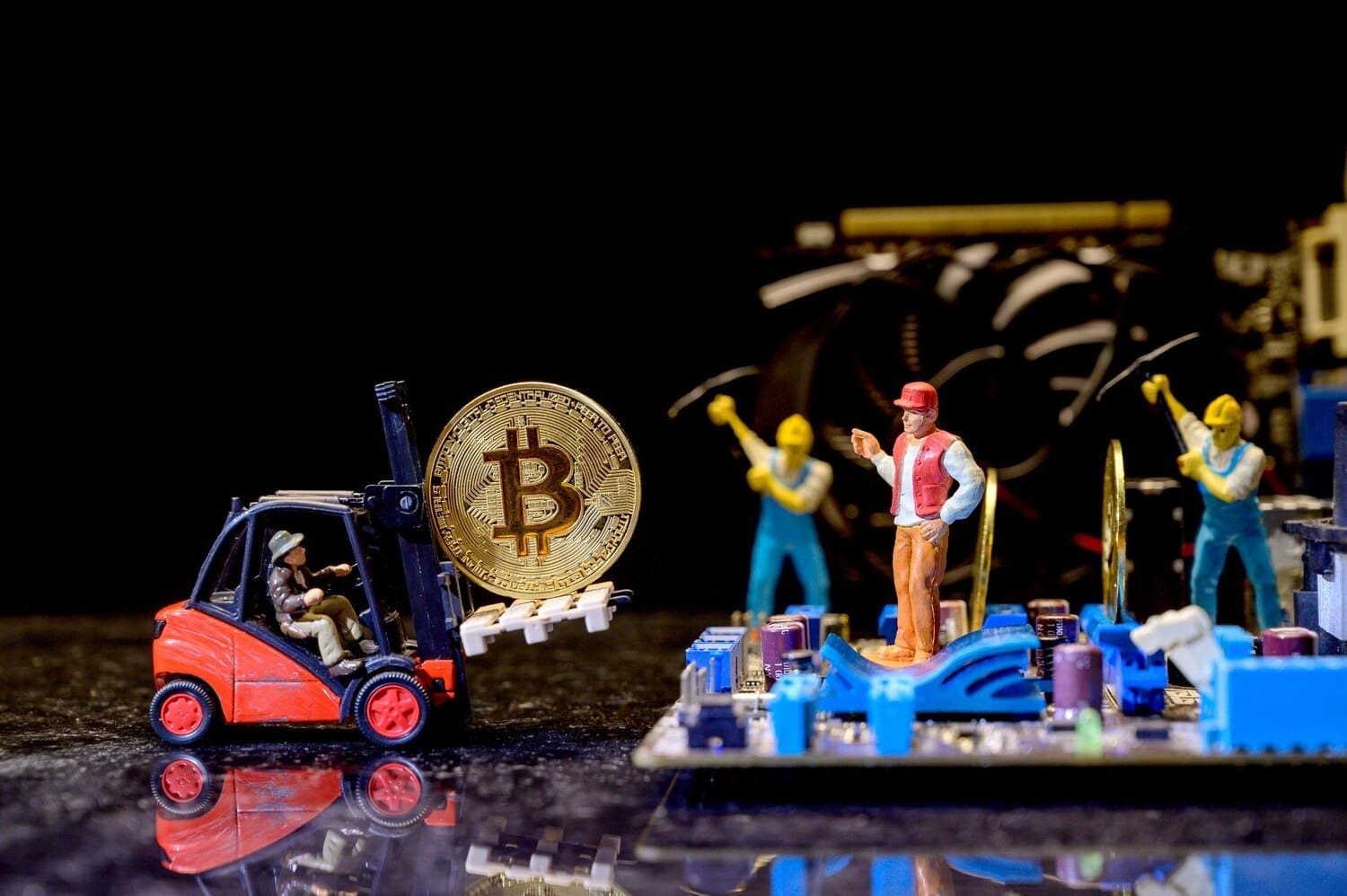 Bitcoin cryptocurrency with gold coins, money, and miniature toys representing blockchain technology.