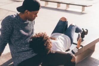 A young Black couple smiles as they take a selfie.