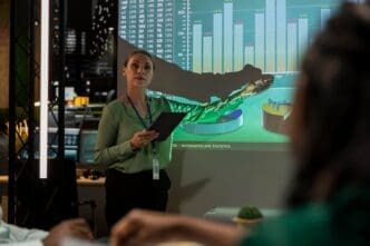 Two business partners are reviewing financial plans displayed on a projector screen.