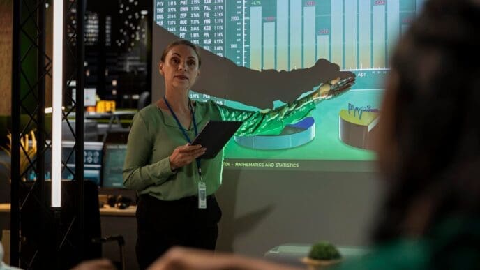 Two business partners are reviewing financial plans displayed on a projector screen.