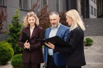 Business people in professional attire conversing in front of a contemporary office building.