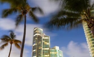 A tall skyscraper rises above other buildings in a bustling city downtown.