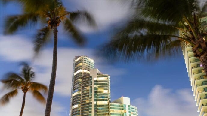 A tall skyscraper rises above other buildings in a bustling city downtown.