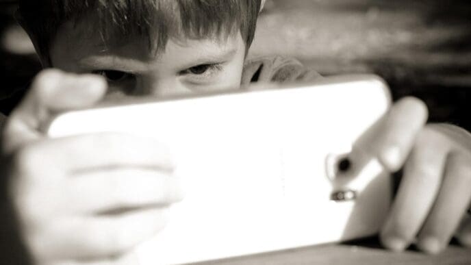 Close-up of a young boy holding a mobile phone.