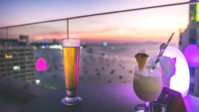 Close-up of a drink on a table is illuminated by the warm light of a sunset.