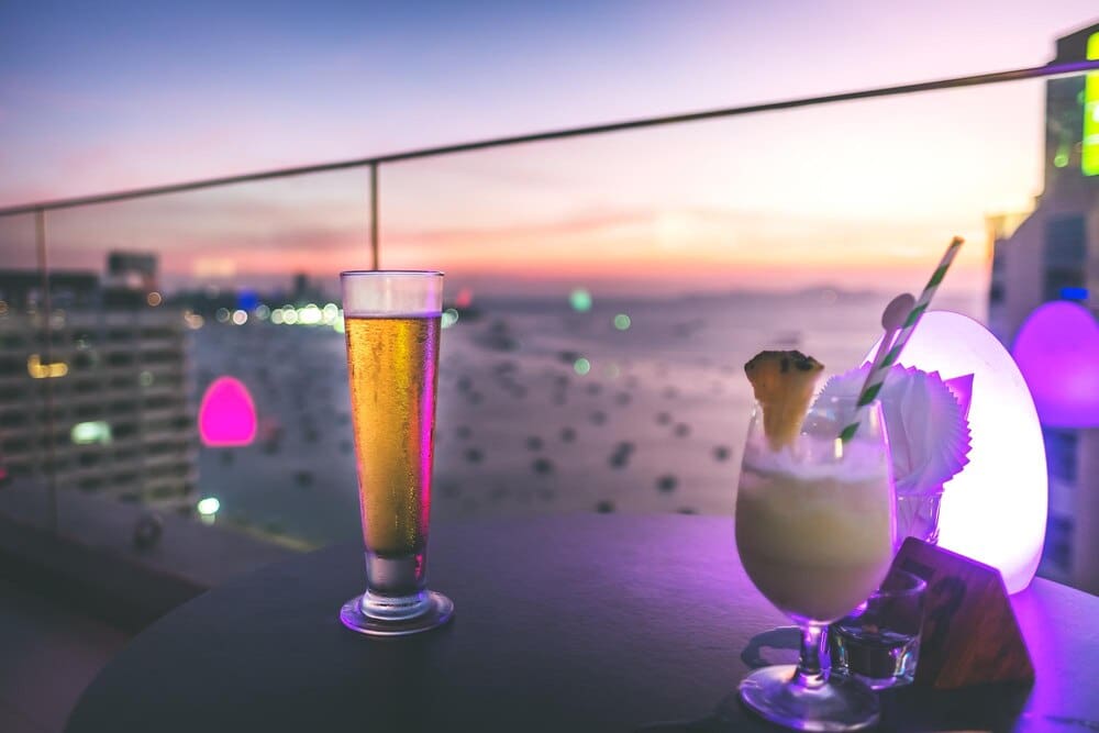 Close-up of a drink on a table is illuminated by the warm light of a sunset.