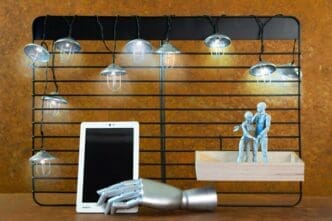 Close-up of an electric lamp with a cylindrical lampshade hanging above a table.