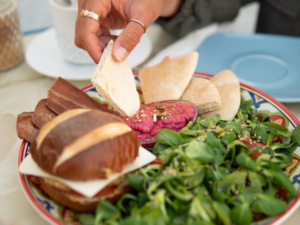 Close-up of a person's hands preparing food on a table.
