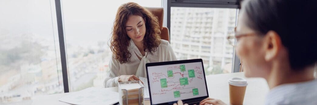 A diverse group of businesspeople collaborates around a large table in a modern office.