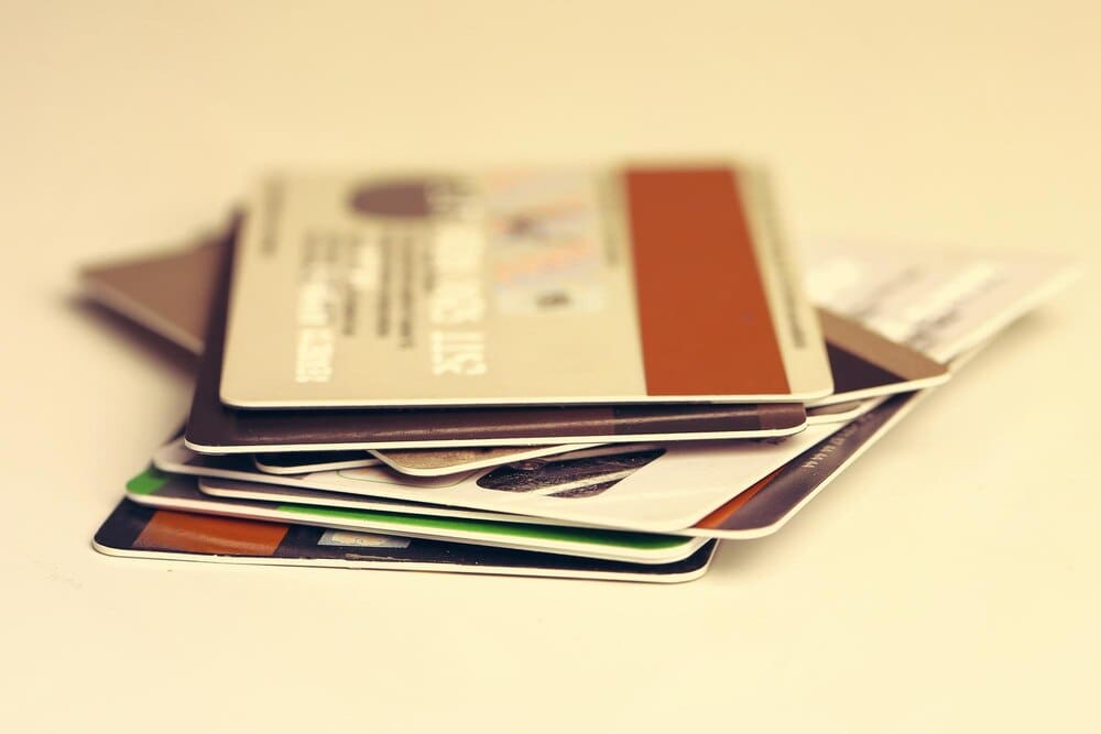 A stack of credit cards of various colors and designs.