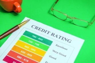 A credit rating form sits on a green desk, accompanied by glasses and a stylish pen.