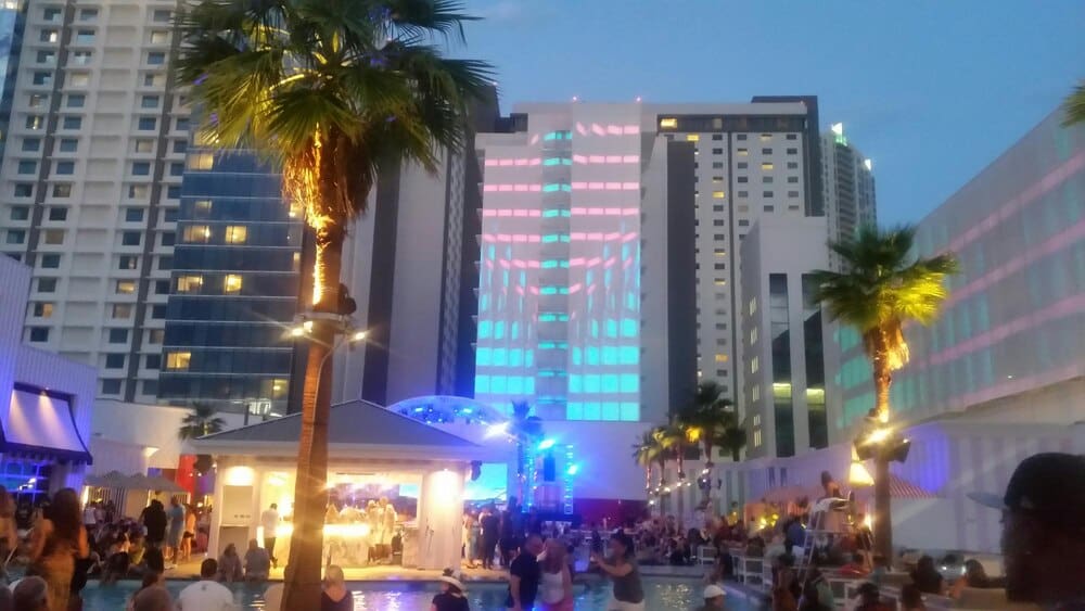 A large group of people are gathered together outdoors at night.