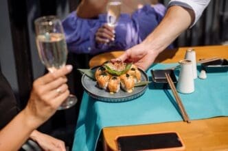 Close-up of a person eating sushi rolls with chopsticks.