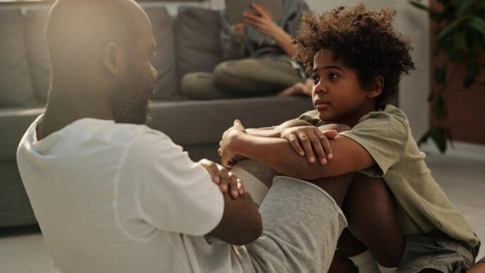 A young boy watches his father as he does sit-ups.