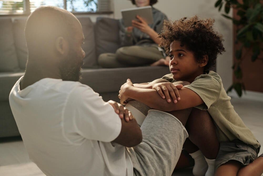 A young boy watches his father as he does sit-ups.