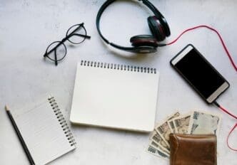 Overhead view of personal accessories, such as a watch, wallet, and keys, arranged neatly on a table.