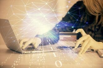 Double exposure shows a woman holding a credit card superimposed with a data-themed hologram related to online shopping.
