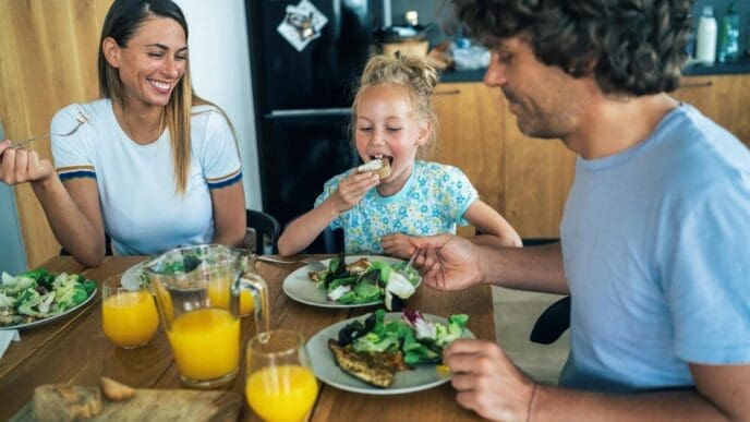 A family is gathered together inside a home, likely engaging in a leisure activity.