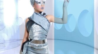 A young girl with silver skin and futuristic clothing touches a glowing finger, with empty space to the right.