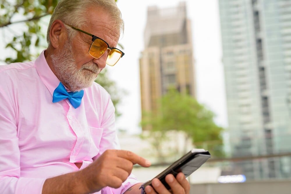 A senior man with a beard explores a city in Bangkok, Thailand.