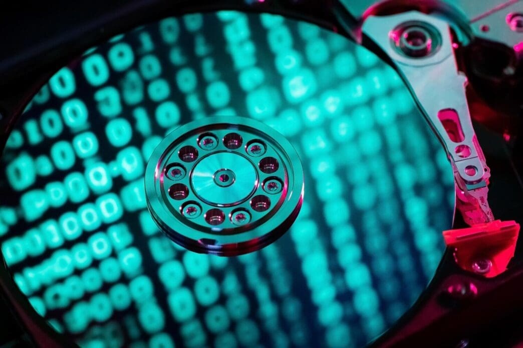 A hard disk drive is displayed with a blue binary code overlay.