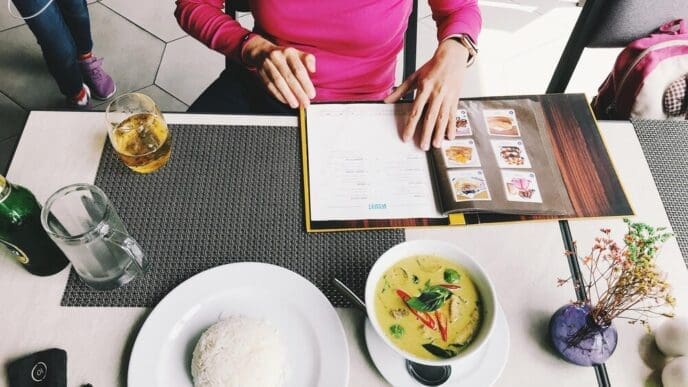 High-angle view of a woman seated at a restaurant table, eating food.